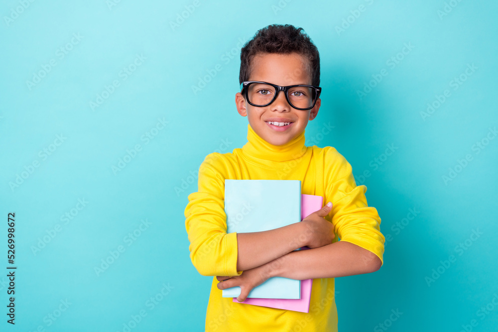 Photo of smart clever boy wear stylish outfit eyeglasses hand arm hug hold diary planner empty space isolated on cyan color background Photo of smart clever boy wear stylish outfit eyeglasses hand arm hug hold diary planner empty space isolated on cyan color background