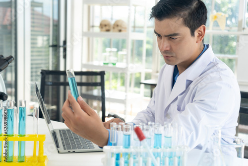 Handsome scientist man holding test tube at laboratory