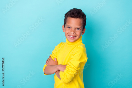 Profile side photo of positive pretty boy wear stylish yellow clothes outfit arm crossed empty space isolated on cyan color background