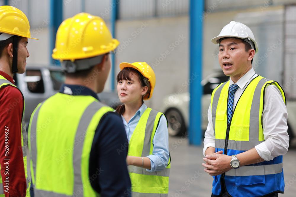 Group of asian technician engineer and businessman in protective uniform standing and discussing, researching, brainstorming and planning work together with hardhat at industry manufacturing factory Group of asian technician engineer and businessman in protective uniform standing and discussing, researching, brainstorming and planning work together with hardhat at industry manufacturing factory