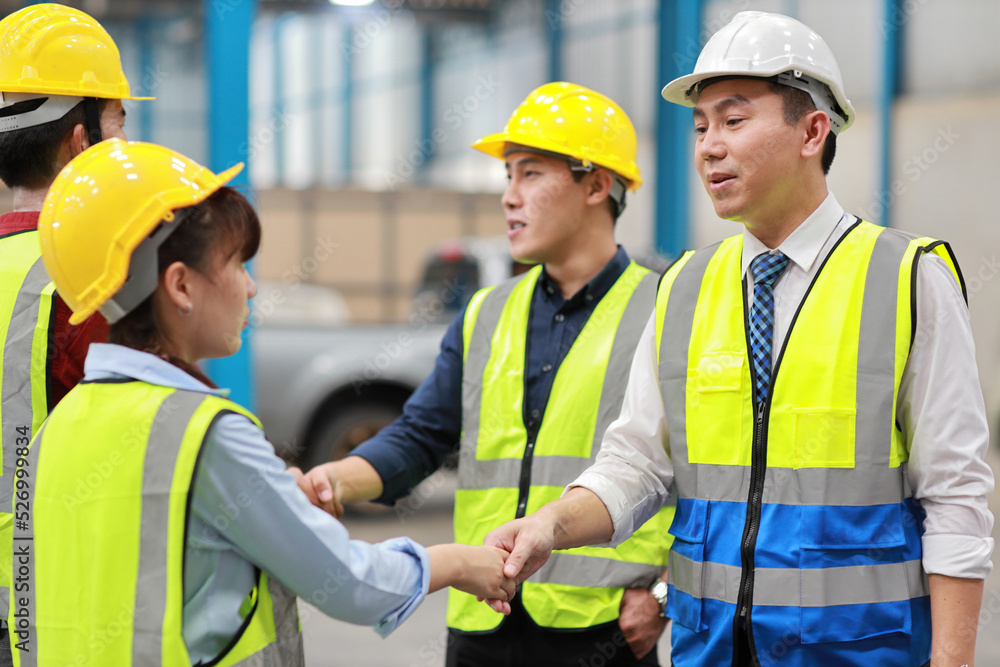 Group of asian technician engineer and businessman in protective uniform standing and discussing, researching, brainstorming and planning work together with hardhat at industry manufacturing factory Group of asian technician engineer and businessman in protective uniform standing and discussing, researching, brainstorming and planning work together with hardhat at industry manufacturing factory
