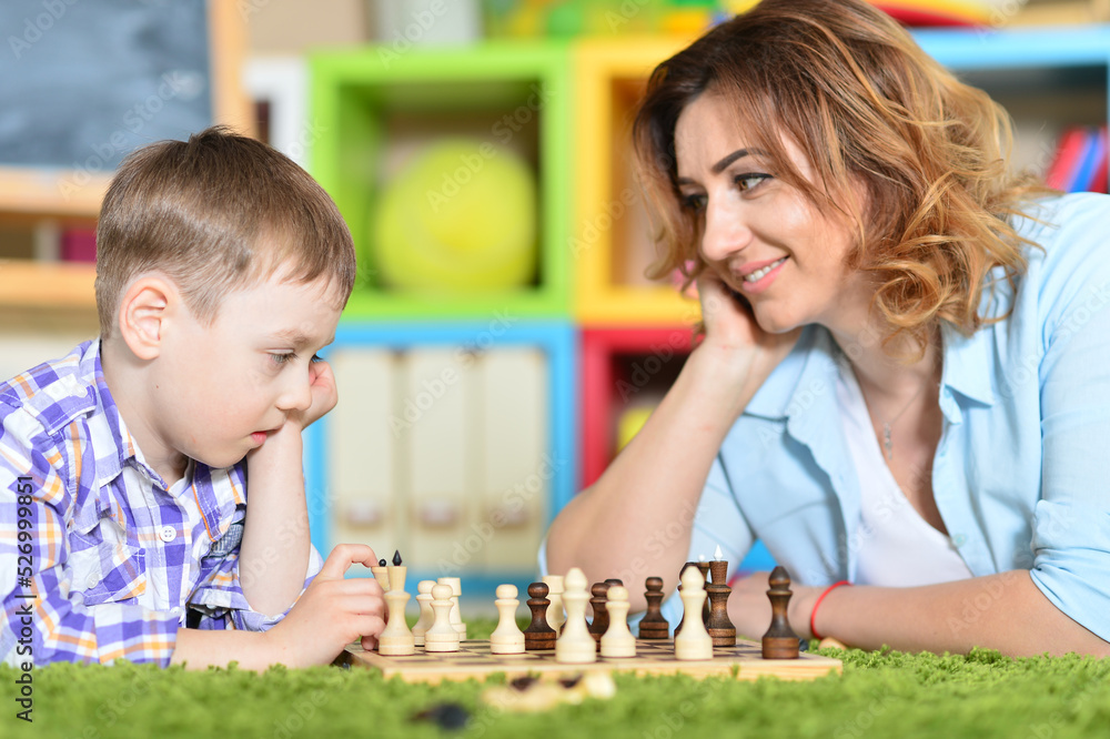 mother with son playing chess at home mother with son playing chess at home