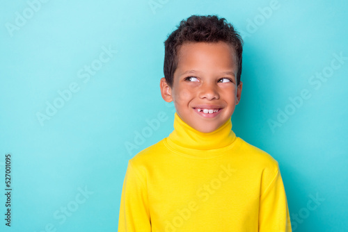 Photo of cheerful minded schoolkid beaming smile look interested empty space isolated on turquoise color background