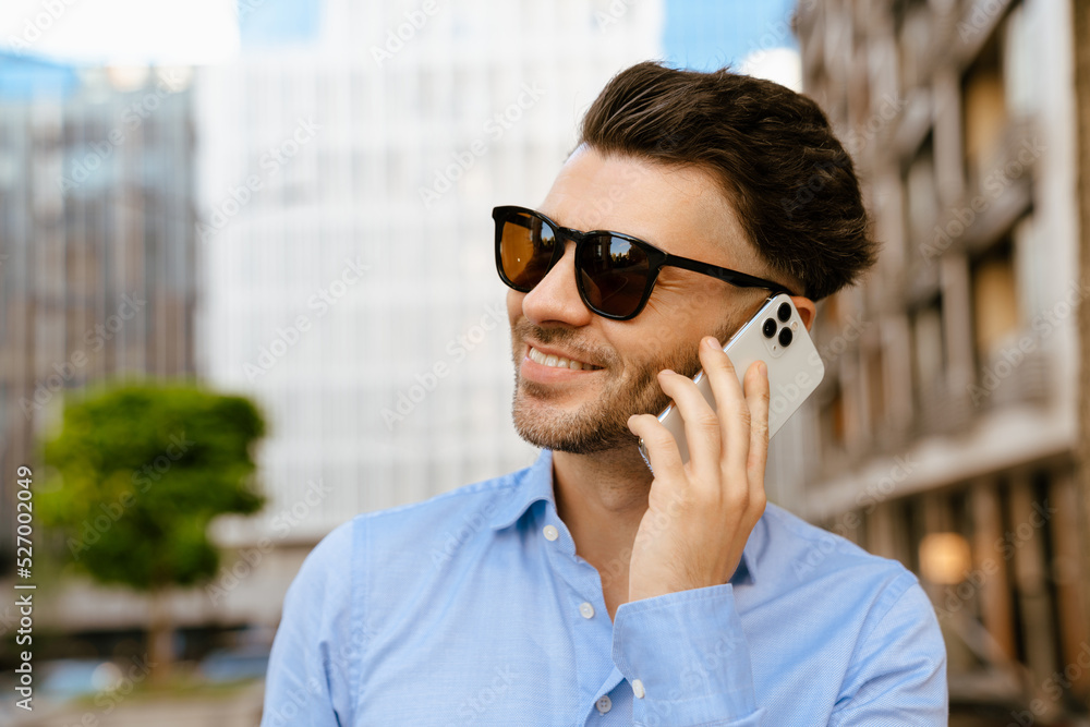 Bristle man wearing sunglasses talking on mobile phone at street Bristle man wearing sunglasses talking on mobile phone at street