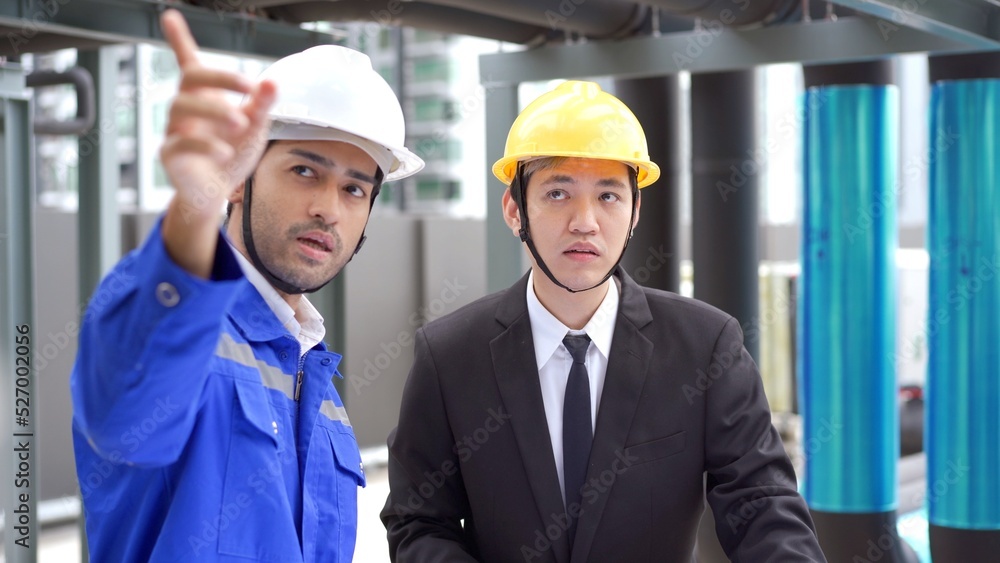 Professional Asian foreman and construction manager talking - discussing about building structure plant together. Professional Asian foreman and construction manager talking - discussing about building structure plant together.