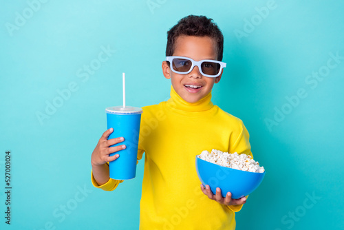 Photo of cute boy stylish clothes eyewear hand arm hold drink plate snack rest relax empty space isolated on cyan color background