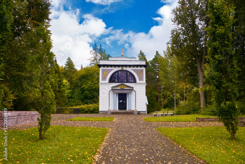 Mausoleum of war general Michael Andreas Barclay de Tolly. Small white chapel in the end of long oak alleyway. Blue sky with clouds, sunny day in Jogeveste Estonia. photo