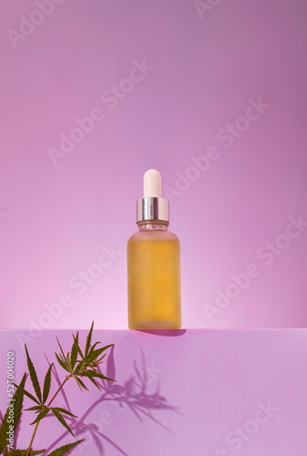 glass bottle with CBD oil, THC tincture on a pastel background with cannabis leaves shadows. Purple background