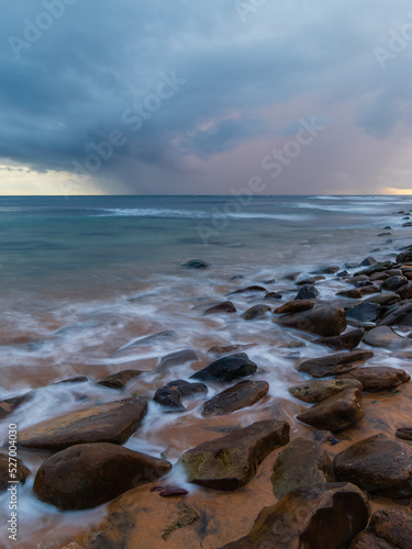 Rocky and cloudy view from rocky beach shore.