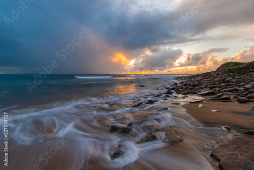 Fototapeta Naklejka Na Ścianę i Meble -  Sunrise view on an rocky beach coastline.