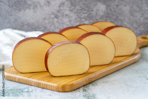 Smoked cheese. Dutch smoked cheese on stone background. close up