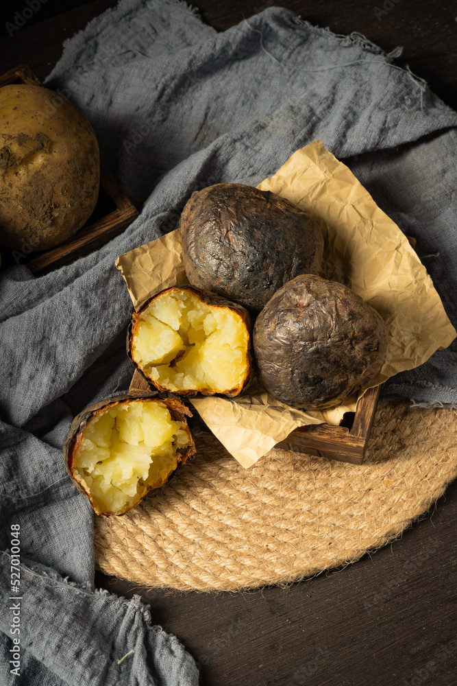 Fresh baked potatoes on a dark background