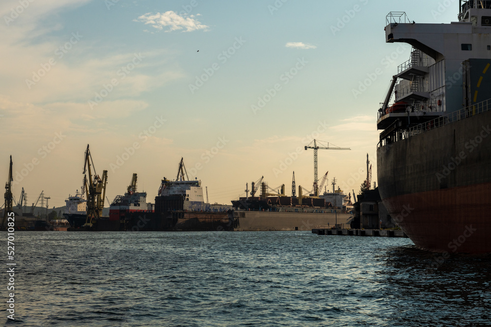 przemysłowa część portu w Gdańsku z licznymi okrętami i dźwigami
