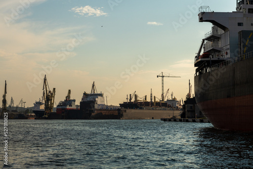 przemysłowa część portu w Gdańsku z licznymi okrętami i dźwigami