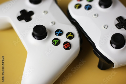Two gaming gamepad buttons close-up on a yellow background