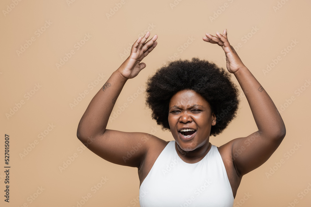 emotional african american plus size woman with raised hands isolated on beige. emotional african american plus size woman with raised hands isolated on beige.