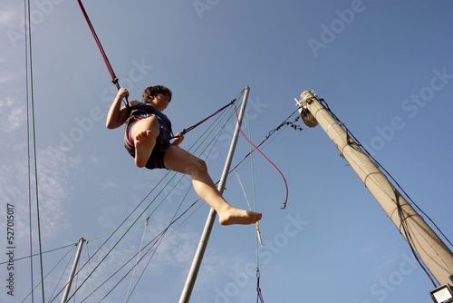teenage girl jumping in a trampoline with security ropes 