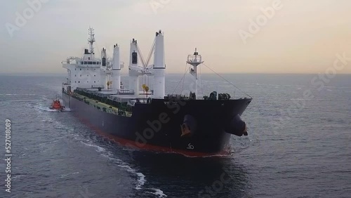 A dry cargo ship underway with a pilot boat at Northern Bosphorus Sea in the early morning. Marine pilots come aboard ships to assist the master and crew to safely navigate through. Aerial of pilotage