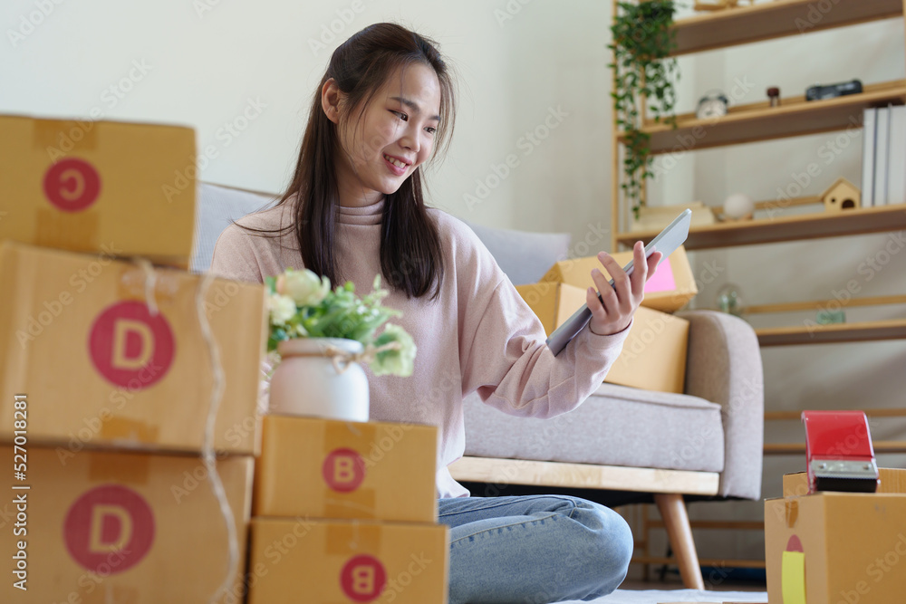 A businesswoman sells items online and checks the goods for packing A businesswoman sells items online and checks the goods for packing