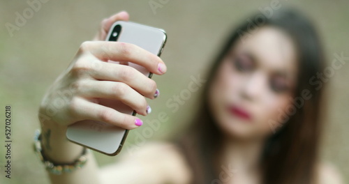 Millennial girl taking selfie of herself with smartphone
