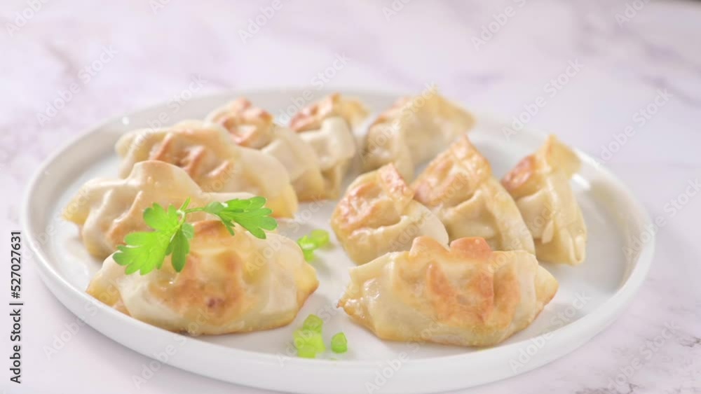 Fried dumplings . Gyoza. Healthy eating and young spring green onions. Asian food. Traditional asian Gyozas on a light background. High quality FullHD footage Fried dumplings . Gyoza. Healthy eating and young spring green onions. Asian food. Traditional asian Gyozas on a light background. High quality FullHD footage