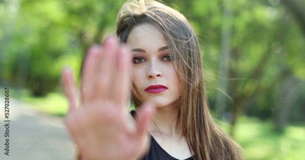 Millennial girl signalling to STOP with hand, woman waving finger gesture Millennial girl signalling to STOP with hand, woman waving finger gesture