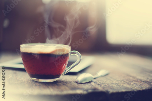 cup of hot coffee with tablet over rustic wooden table 