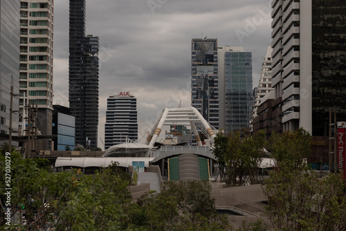 Chong Nonsi Canal Park. New park in city center surrounded green trees and stone courtyard in front of canal with skyscraper background. Focus and blur. photo