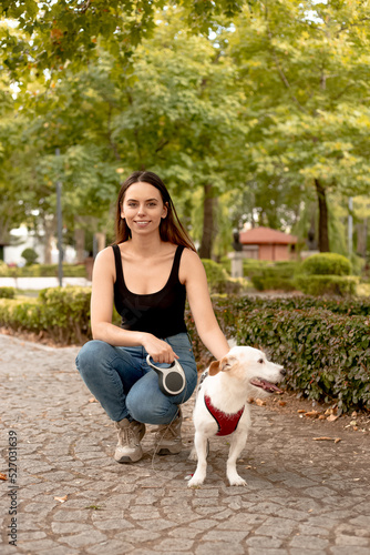 Young woman outdoors with a jack russell dog.Blurred background. 