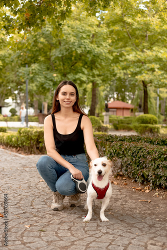 Young woman outdoors with a jack russell dog.Blurred background. 