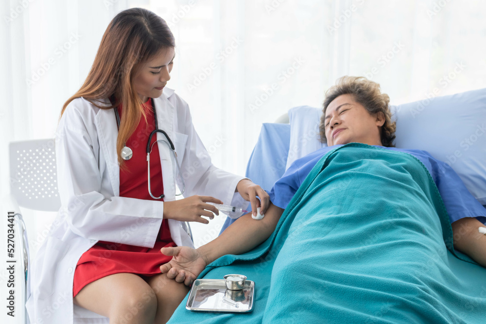An Asian female doctor is making an injection in the shoulder of a patient in a hospital. An Asian female doctor is making an injection in the shoulder of a patient in a hospital.