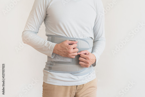 Back pain , man suffering from backache , office syndrome , Backache and lower back pain concept , support belt for back muscles .