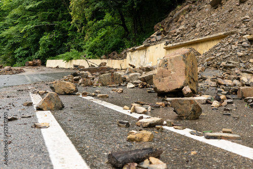 Scattered stones on the road. Rockfall. Rockfall on the road. Large rocks of rock fell on the asphalt road.