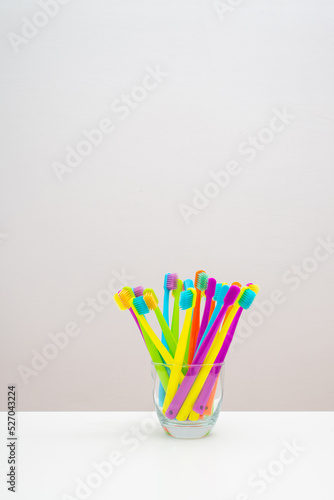 Photo of a modern colorfull toothbrush with differ colors like yellow, violet, blue, green on a white background and marble background flat lay style in studio 