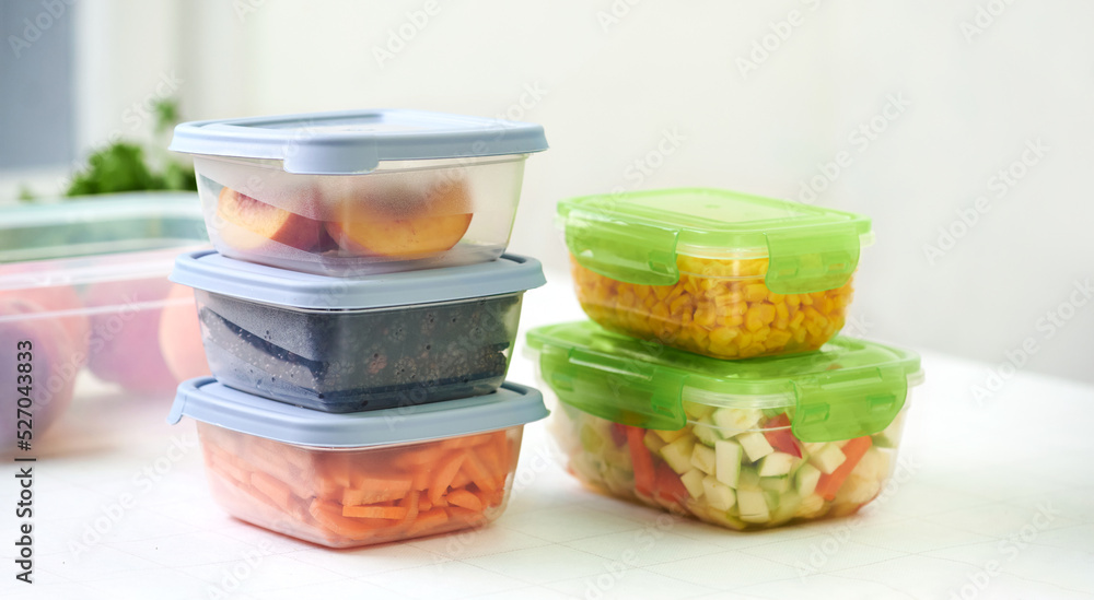 Plastic containers with raw cut vegetables for freezing on kitchen table.  Storage for winter storage in trays Stock Photo