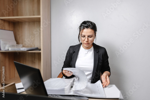 Canvastavla Image of a woman jotting down notes while sitting at a desk in an office