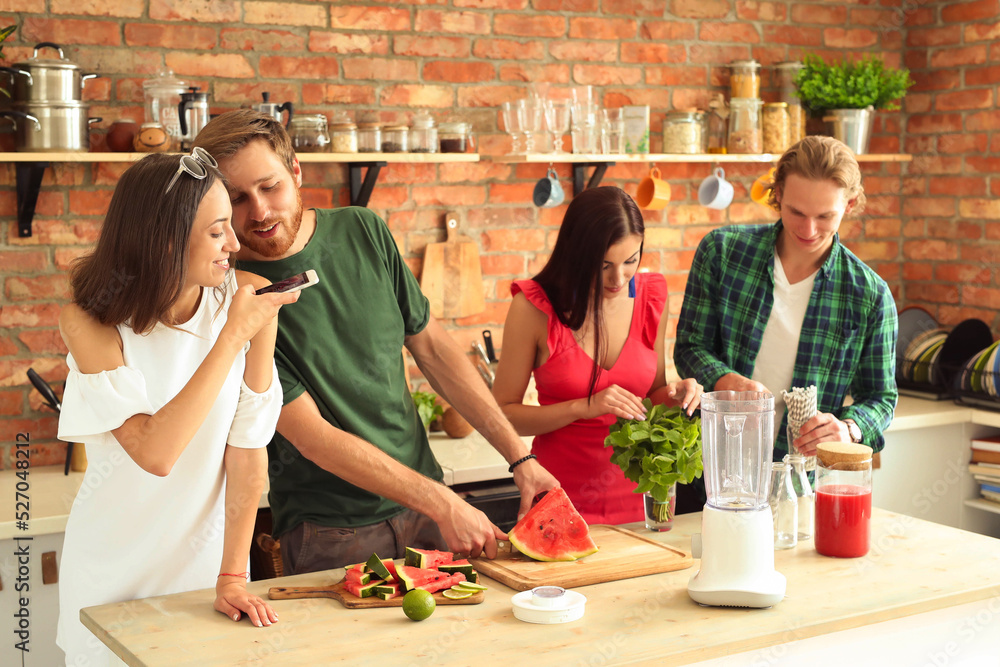 Get the party started with this fun and vibrant stock photo of a group of people enjoying food and drinks in the kitchen.
