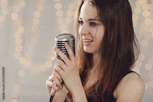 This dynamic and passionate singer with dark locks captures the essence of music as she poses with a microphone in the studio, delivering a range of poses perfect for music industry publications