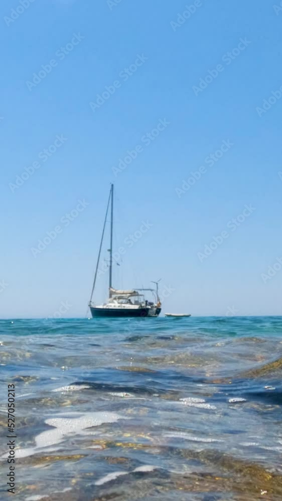 Vertical screen. Amazing view of clear turquoise color of sea, seascape with yacht at bay, pleasure of sailing. Clear blue sky on a sunny day. Summer travel holidays concept. Slow motion 4K footage. Vertical screen. Amazing view of clear turquoise color of sea, seascape with yacht at bay, pleasure of sailing. Clear blue sky on a sunny day. Summer travel holidays concept. Slow motion 4K footage.