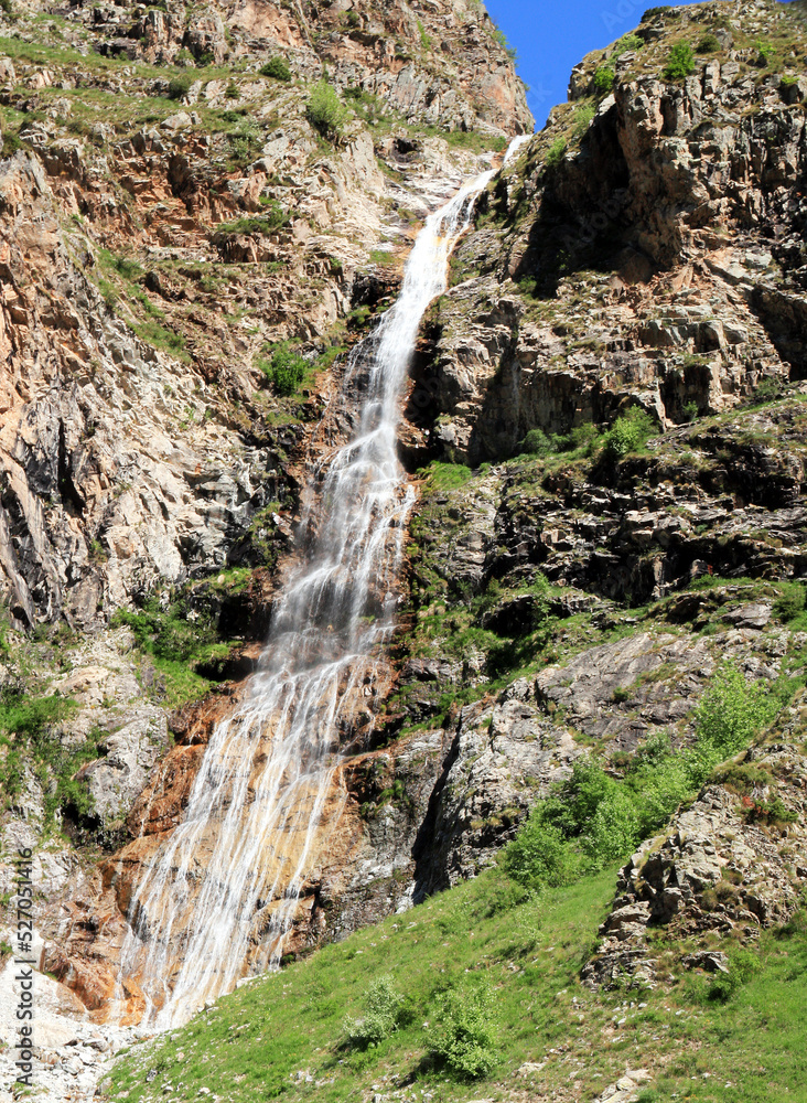 Haute cascade descendant une falaise de rochers dans les Alpes. Haute cascade descendant une falaise de rochers dans les Alpes.