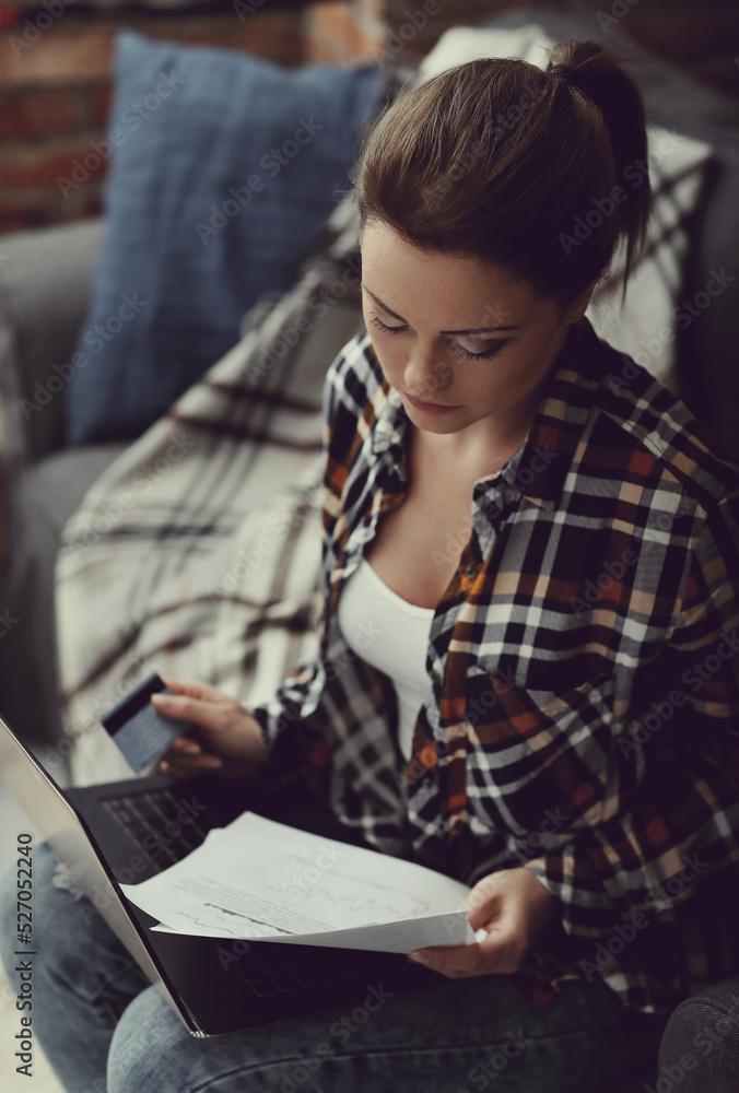 A brown-haired girl looks confident and professional while posing for photos on her sofa at home, checking important documents. A brown-haired girl looks confident and professional while posing for photos on her sofa at home, checking important documents.