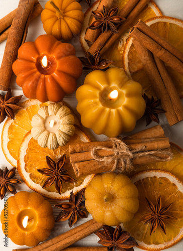 Autumn composition.Pumpkin candles,spicy star anise spices and cinnamon on a white wooden background.Cozy home decor.Halloween concept.Happy Thanksgiving.Flat lay.Copy space.