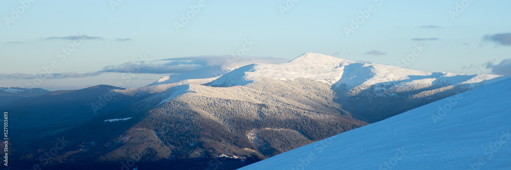 Chornohora ridge in the Carpathians in winter. Mount Petros and Hoverla are covered with snow. Web banner, sunset light