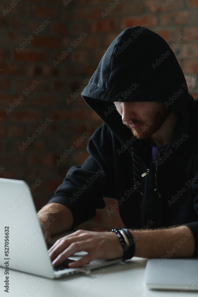 Behind the Screen: A Hacker's World Revealed as He Works on His Computer in a House Near the Window Behind the Screen: A Hacker's World Revealed as He Works on His Computer in a House Near the Window