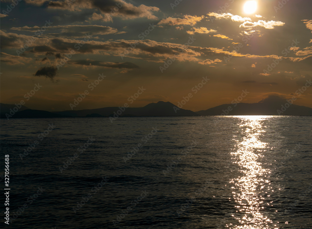 The path of the sun reflection on the water lays under the spectacular morning sky. Romantic, relaxing and tranquil panorama.