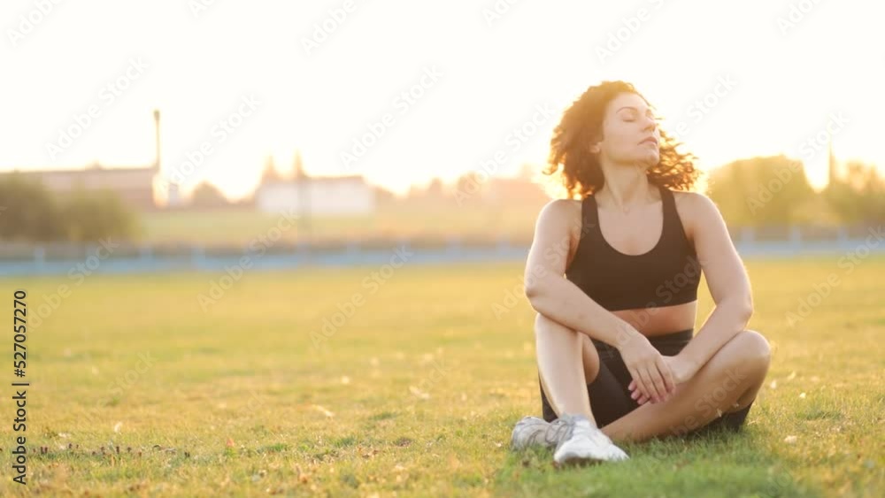 curly athletic woman resting recovering after workout outdoors. curly athletic woman resting recovering after workout outdoors.