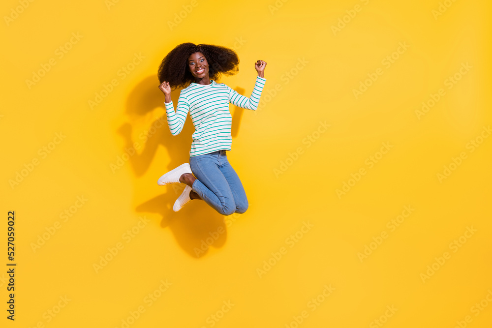 Full size portrait of delighted cheerful person raise fists celebrate attainment isolated on yellow color background Full size portrait of delighted cheerful person raise fists celebrate attainment isolated on yellow color background