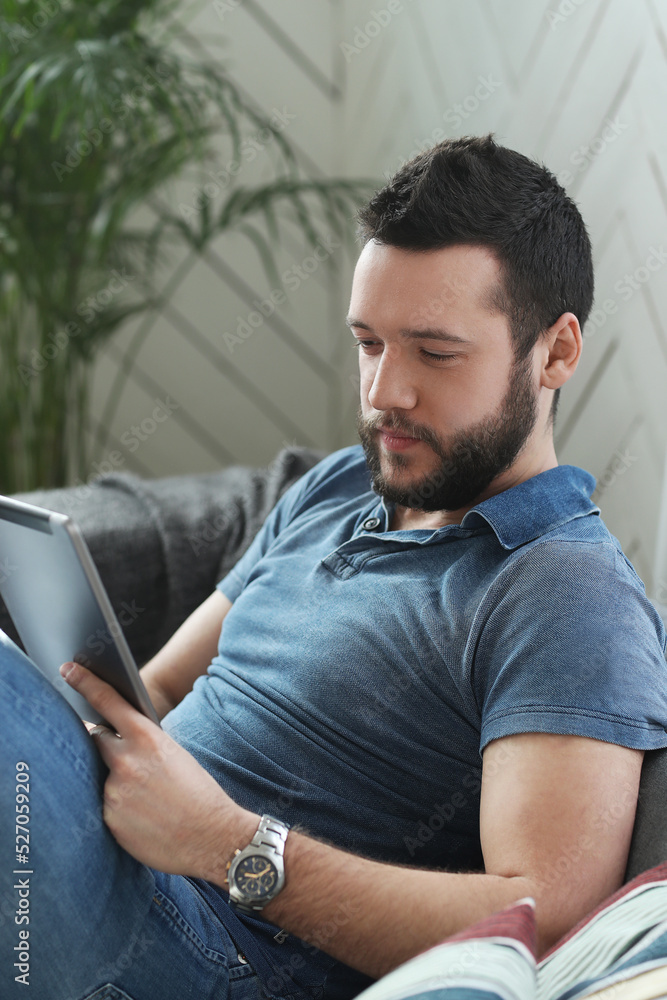 Handsome young man with beard using laptop at home Handsome young man with beard using laptop at home