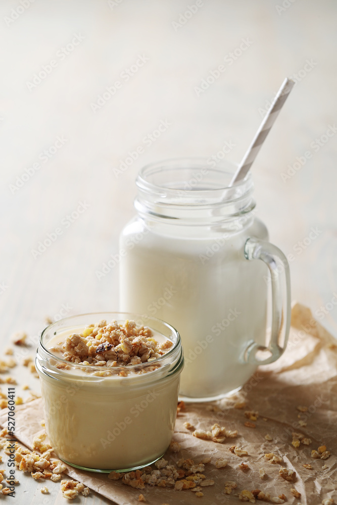 Homemade cooked healthy granola for breakfast in a wooden bowl on the table and near a bottle of milk. Place for text. Fitness food, snack Homemade cooked healthy granola for breakfast in a wooden bowl on the table and near a bottle of milk. Place for text. Fitness food, snack