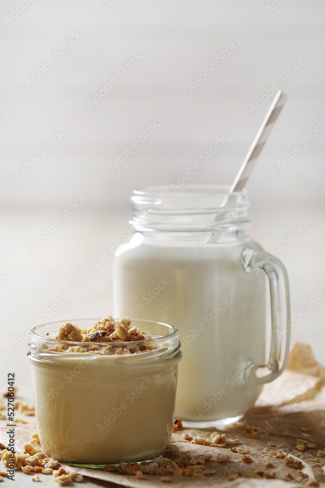 Homemade cooked healthy granola for breakfast in a wooden bowl on the table and near a bottle of milk. Place for text. Fitness food, snack Homemade cooked healthy granola for breakfast in a wooden bowl on the table and near a bottle of milk. Place for text. Fitness food, snack